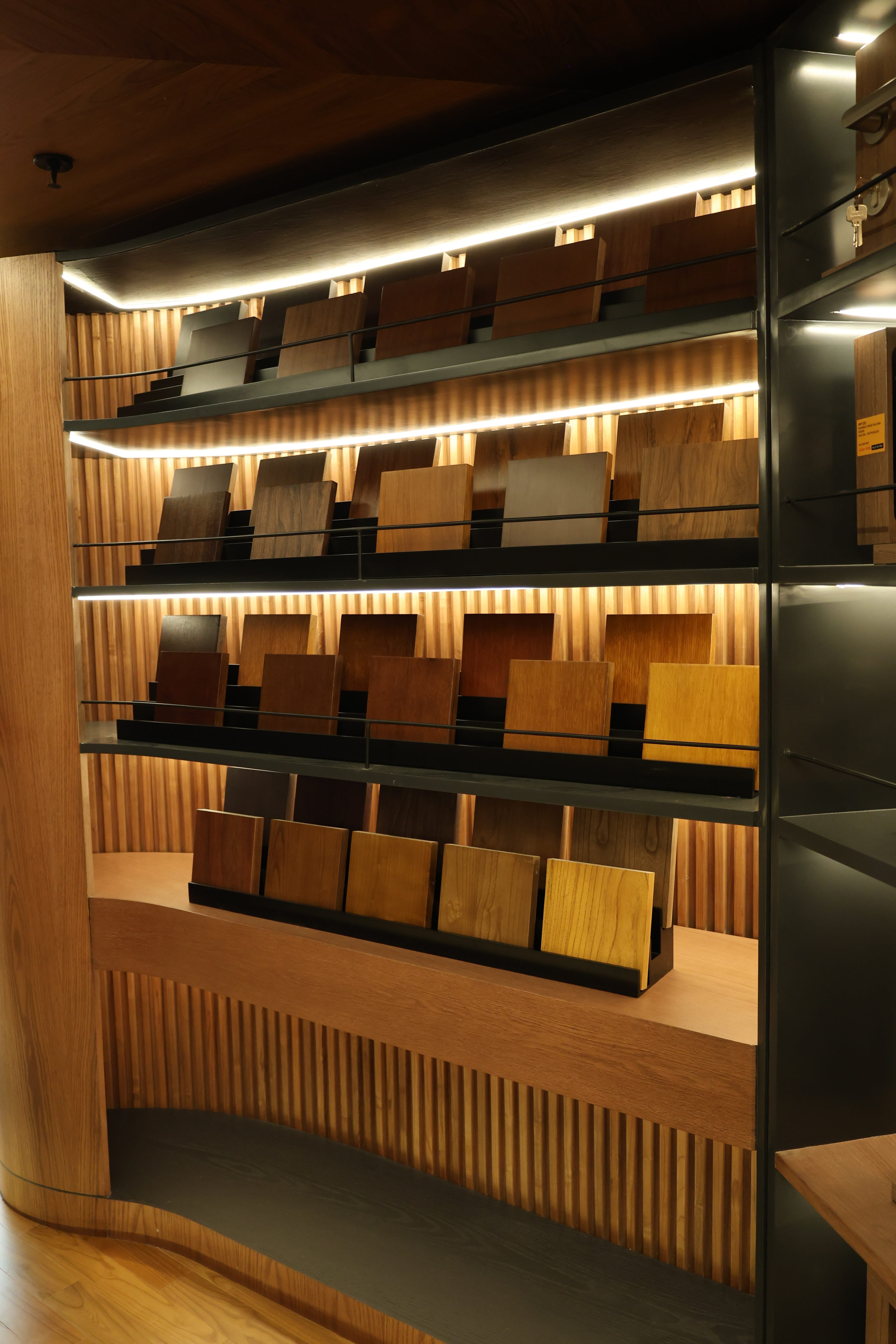 Wood species sample wall with illuminated display blocks at Reywood showroom Jakarta
